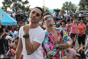 Crowd of people wearing colorful clothing with 2 men in the front with Noz's environmentally safe sunscreen on their nose.